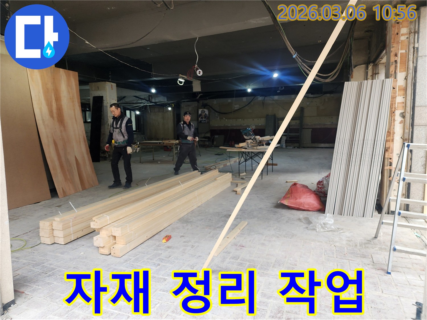 누수 복구 공사를 위해-현장에 도착한 전문 작업자들이-필요한 자재들을 효율적으로 정리하는 장면