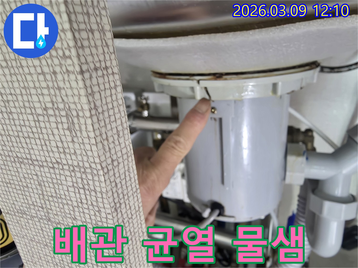 전문가가-배관에 발생한-미세한 균열을-누수 원인으로-지목하며-고객에게-설명하는-장면입니다.