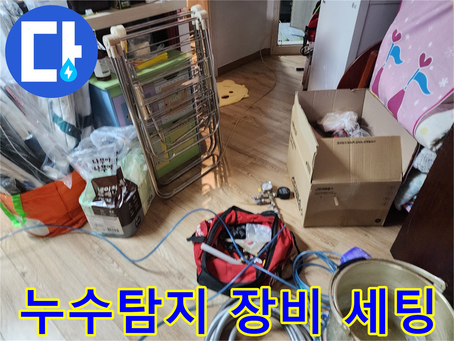 누수 탐지를 위해 준비된 전문 장비와 공구 가방이 거실 바닥에 놓여 있습니다.