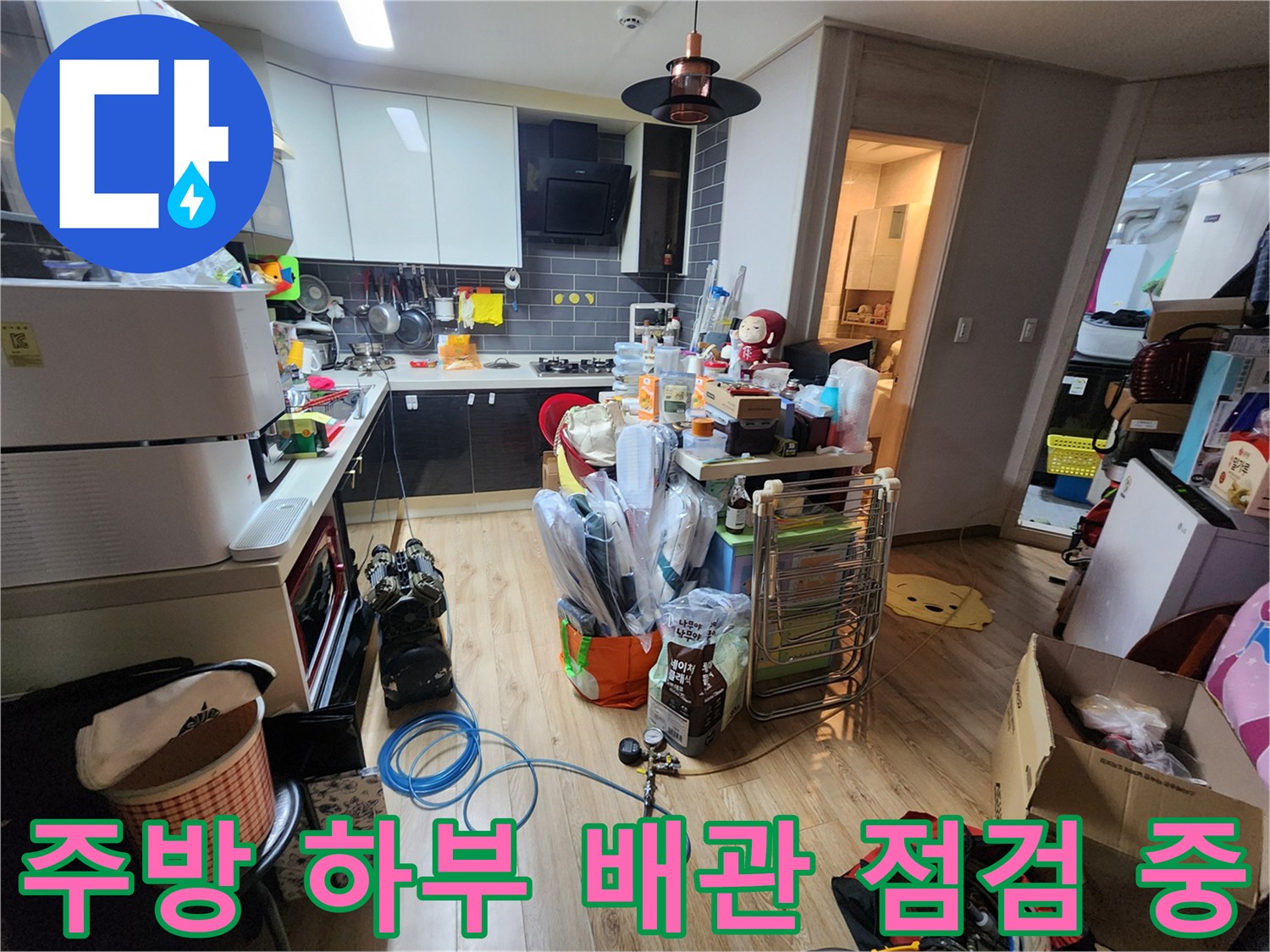 싱크대 밑 공간에서 진행되는 배관 누수 진단 및 점검 모습입니다.
