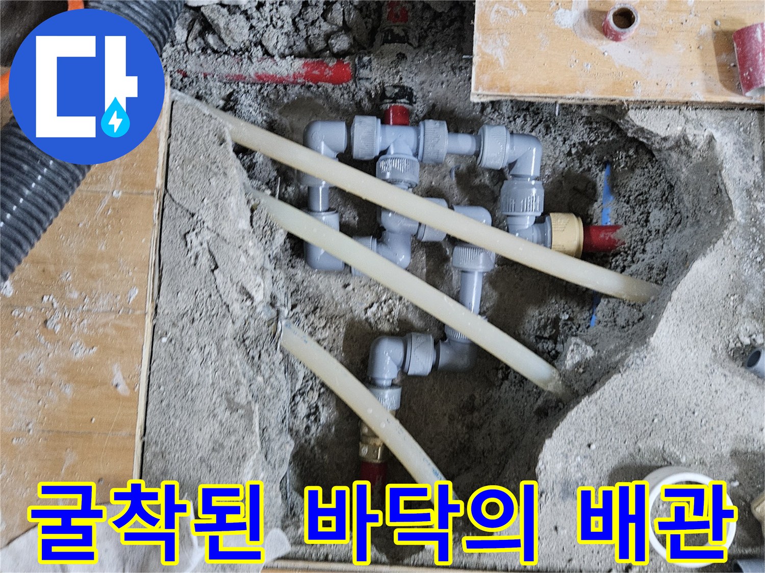 시멘트가 파헤쳐진 바닥 속 노출된 배관과 작업 도구들