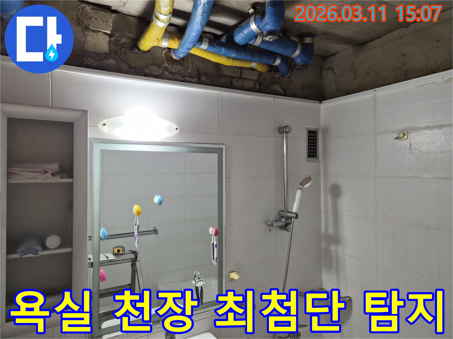 욕실 천장 내부의-파란색과 노란색 배관들이-최첨단 장비로-누수 지점을 탐지하기 위해-노출된 모습