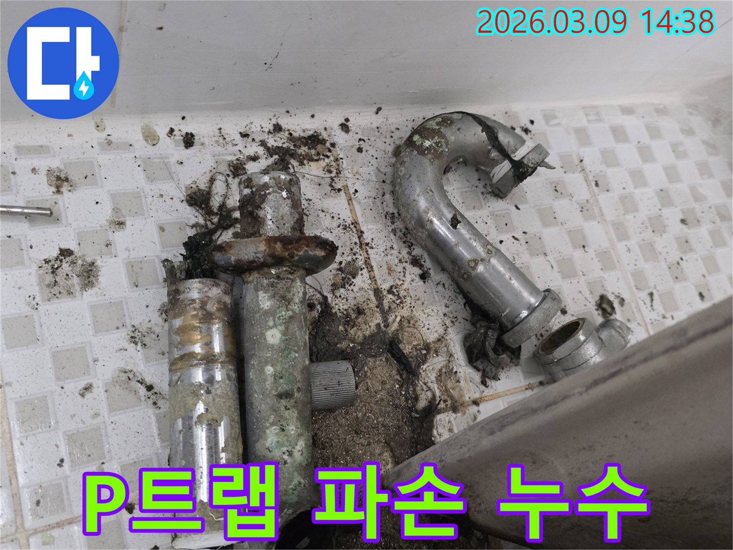 이 이미지는 노원구 공릉동 화장실의-심하게 파손되어 누수가 발생한 P트랩과-주변의 오염된 바닥을 보여줍니다-악취와 누수를 동시에 해결해야 합니다