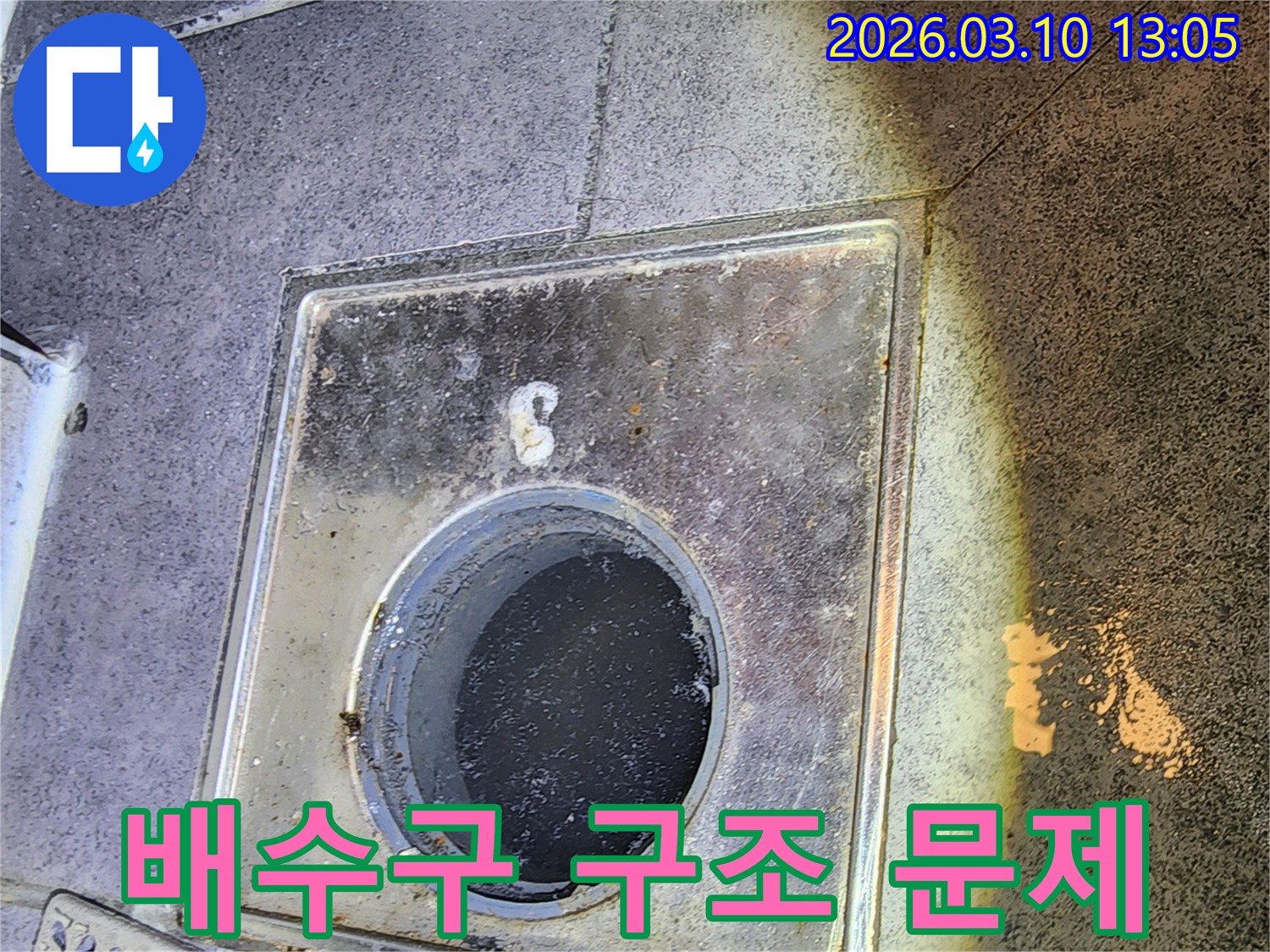 누수 엔지니어가 바닥 배수구 덮개를 열고-배수구 자체의 구조적 문제나 시공 불량 여부를 진단하는 모습입니다