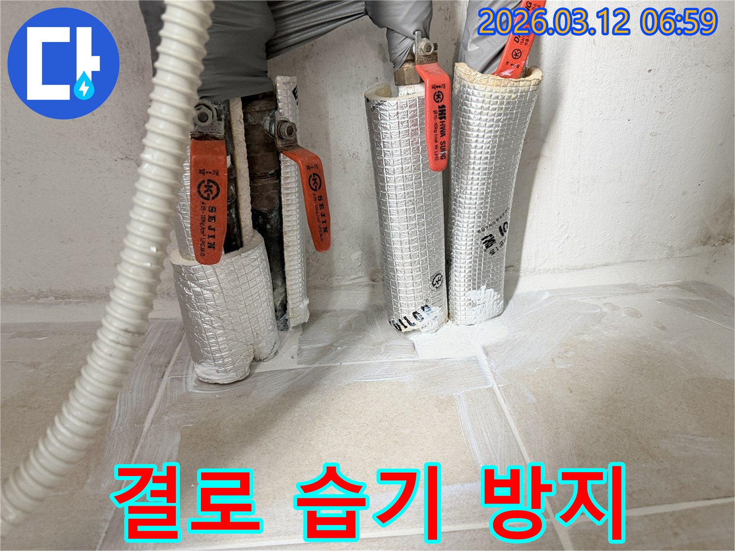 누수-공사-현장에서-배관-결로를-방지하고-습기를-제거하기-위해-보온재를-시공하는-모습