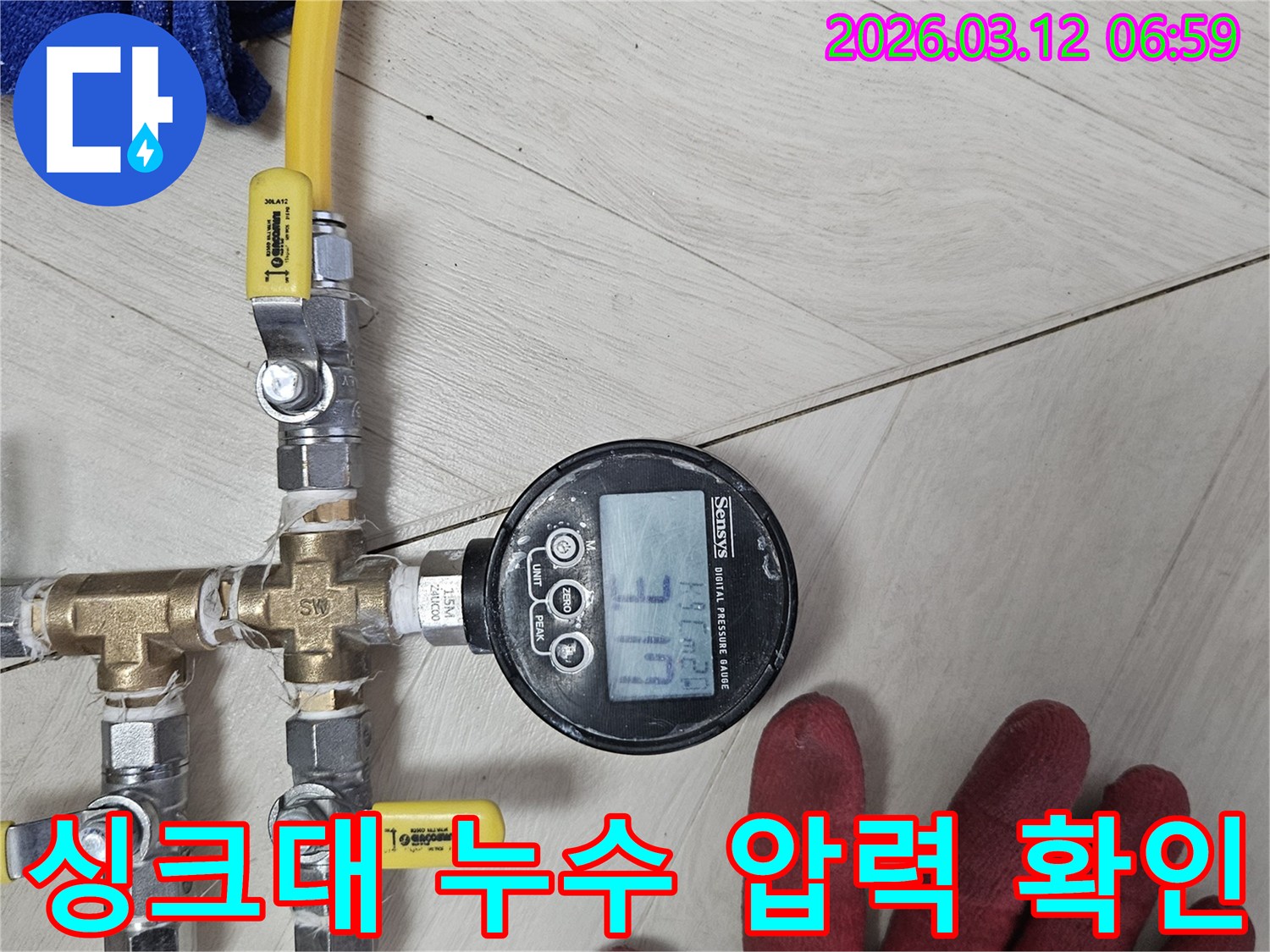 누수-탐지-전문가가-첨단-디지털-압력계로-배관-압력을-정밀하게-측정하여-싱크대-주변-숨은-누수를-찾아내는-모습