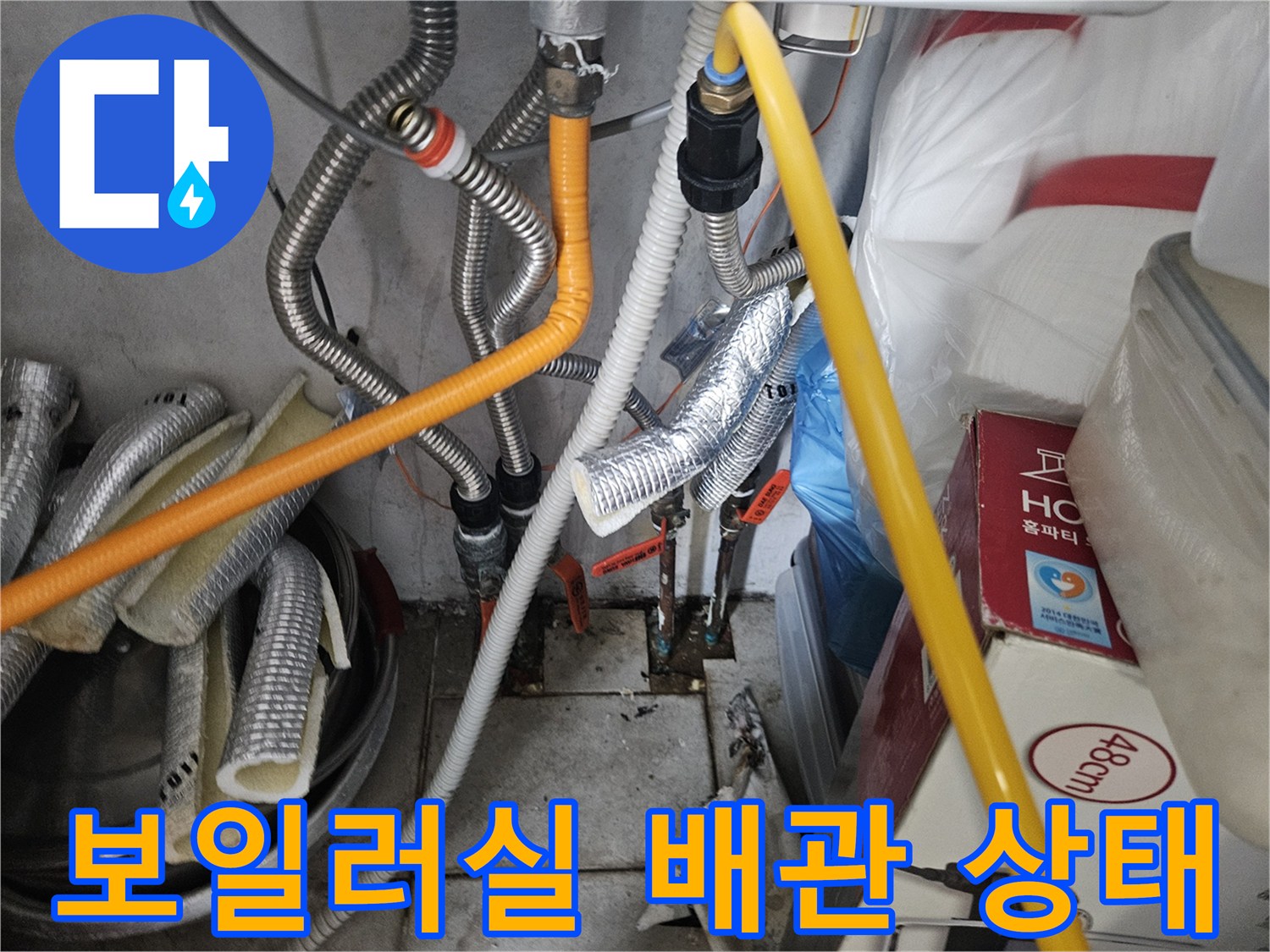 보일러실 내부에 복잡하게 얽힌 은색 주름관과 노란색 호스 배관 모습