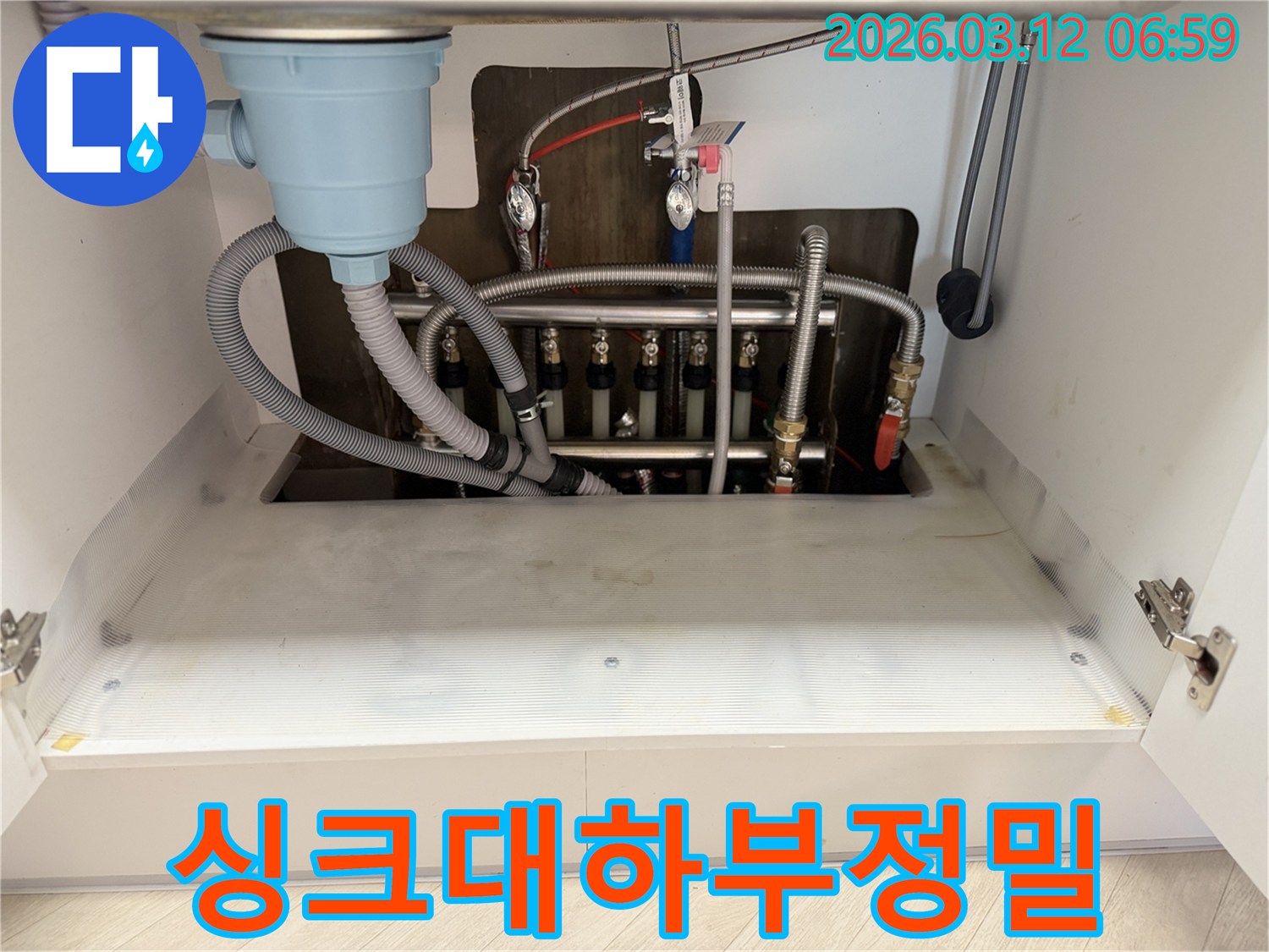 주방-싱크대-하부에서-발생한-물샘-현상을-해결하기-위해-누수-전문가가-배관을-정밀-점검하는-모습입니다.