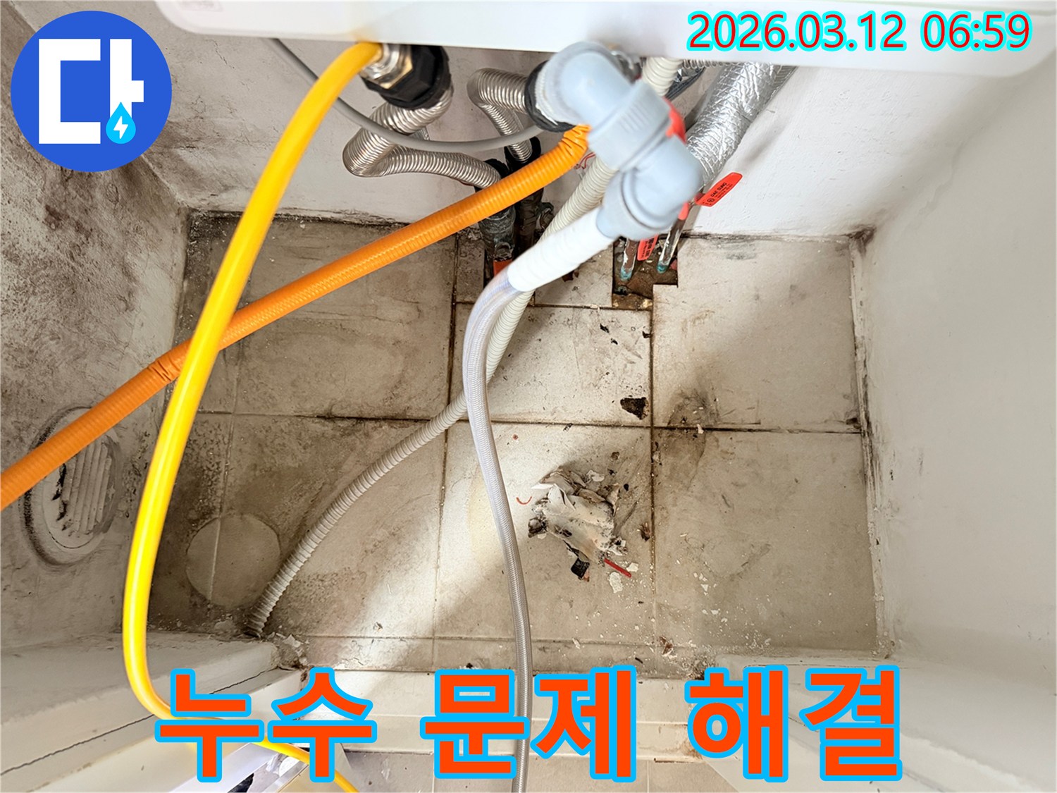 화장실 바닥의-오염된 타일과-벽면의 곰팡이-그리고 복잡한 배관들이-누수 문제를 시사하는-현장 사진입니다.