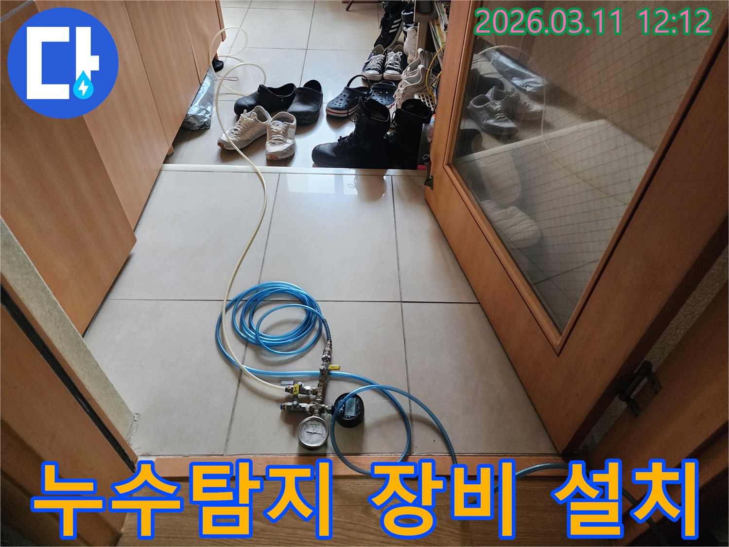 누수 탐지 작업을 위해 압력 게이지가 달린 호스를 연결하고 있는 모습