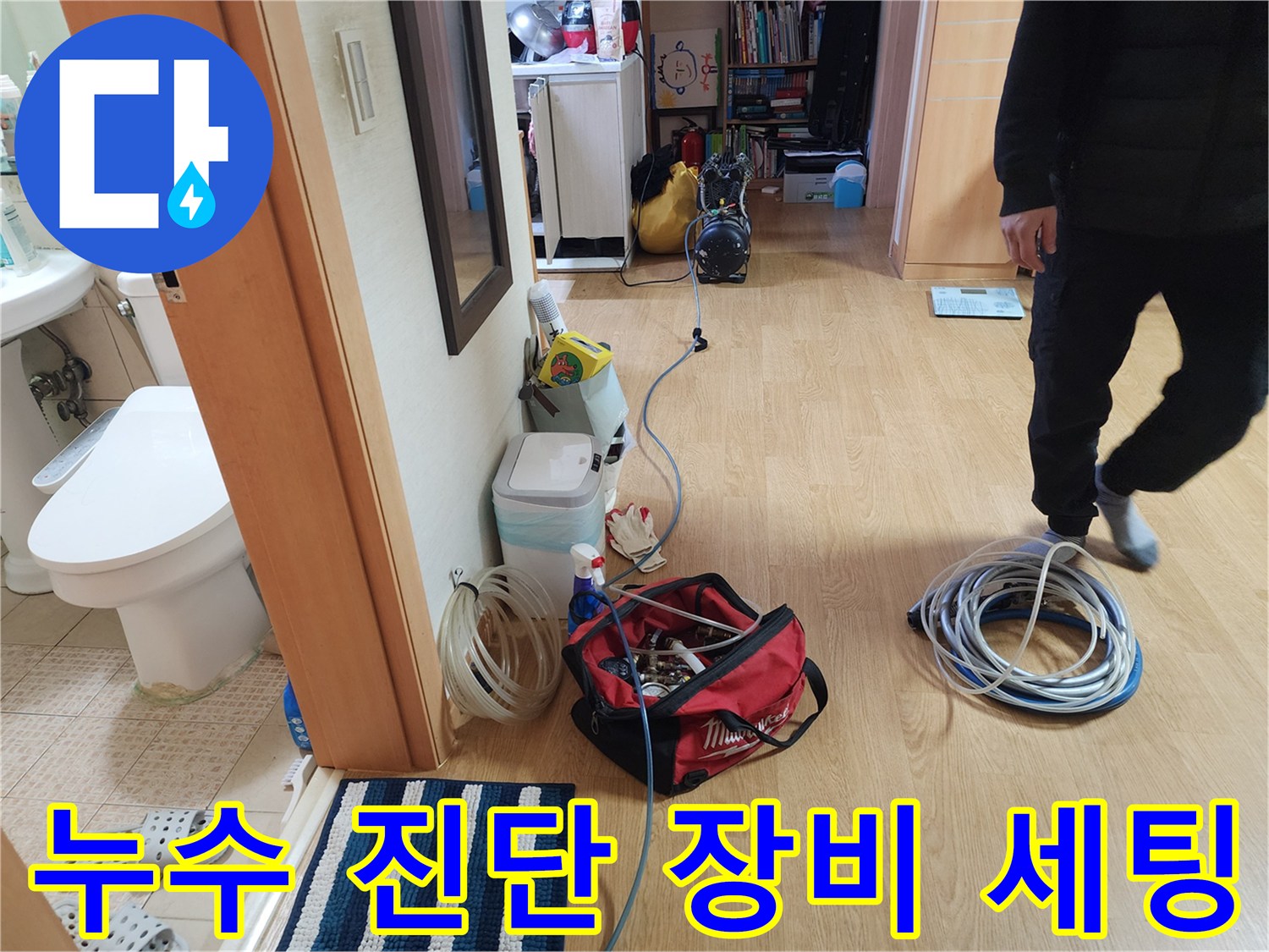 누수 탐지를 위해 거실 바닥에 준비된 공압 테스트용 호스와 전문 장비 모습입니다.