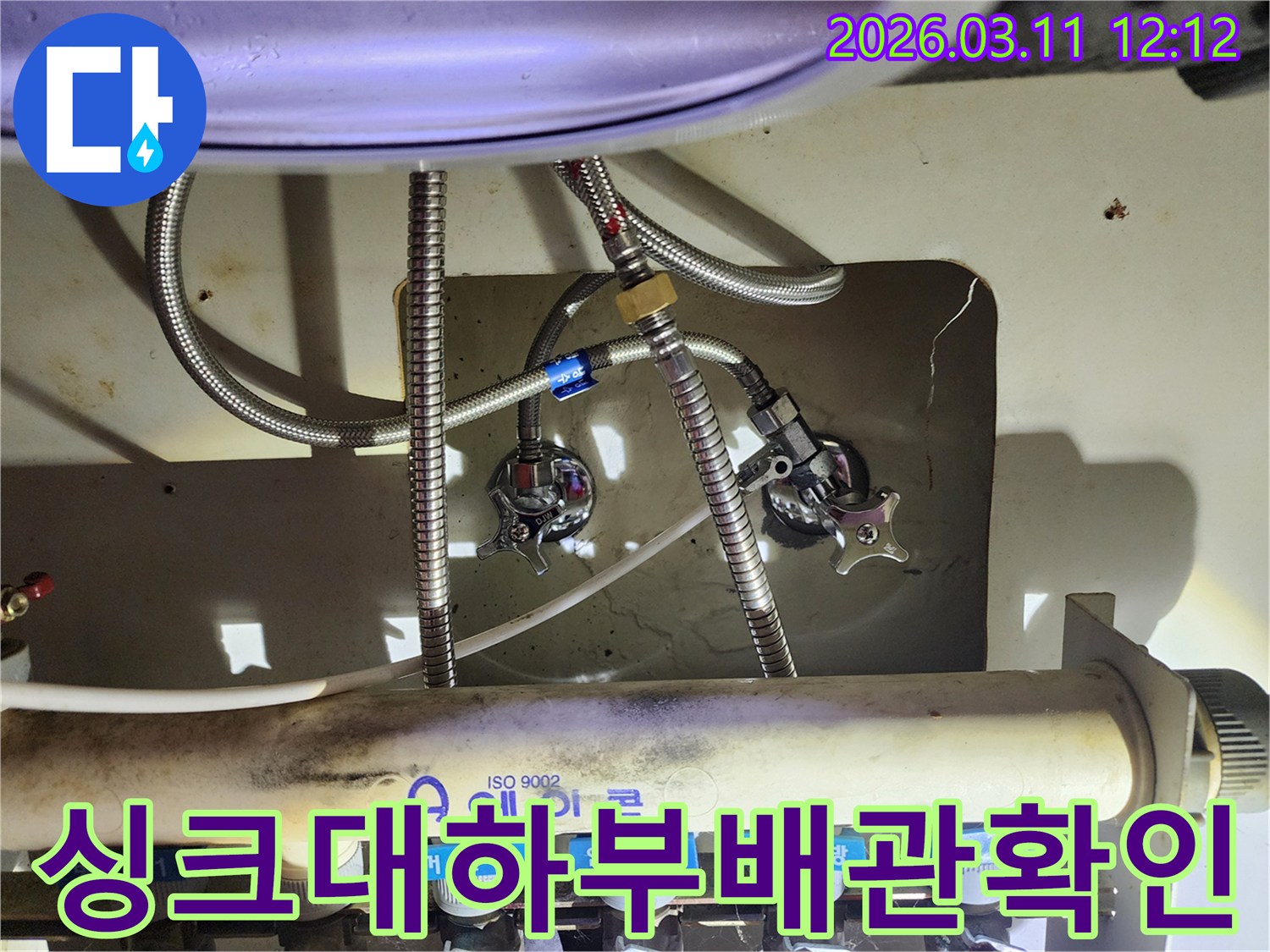 다수의-수도-배관과-밸브가-복잡하게-얽혀있는-싱크대-아래쪽-부분을-확대한-이미지