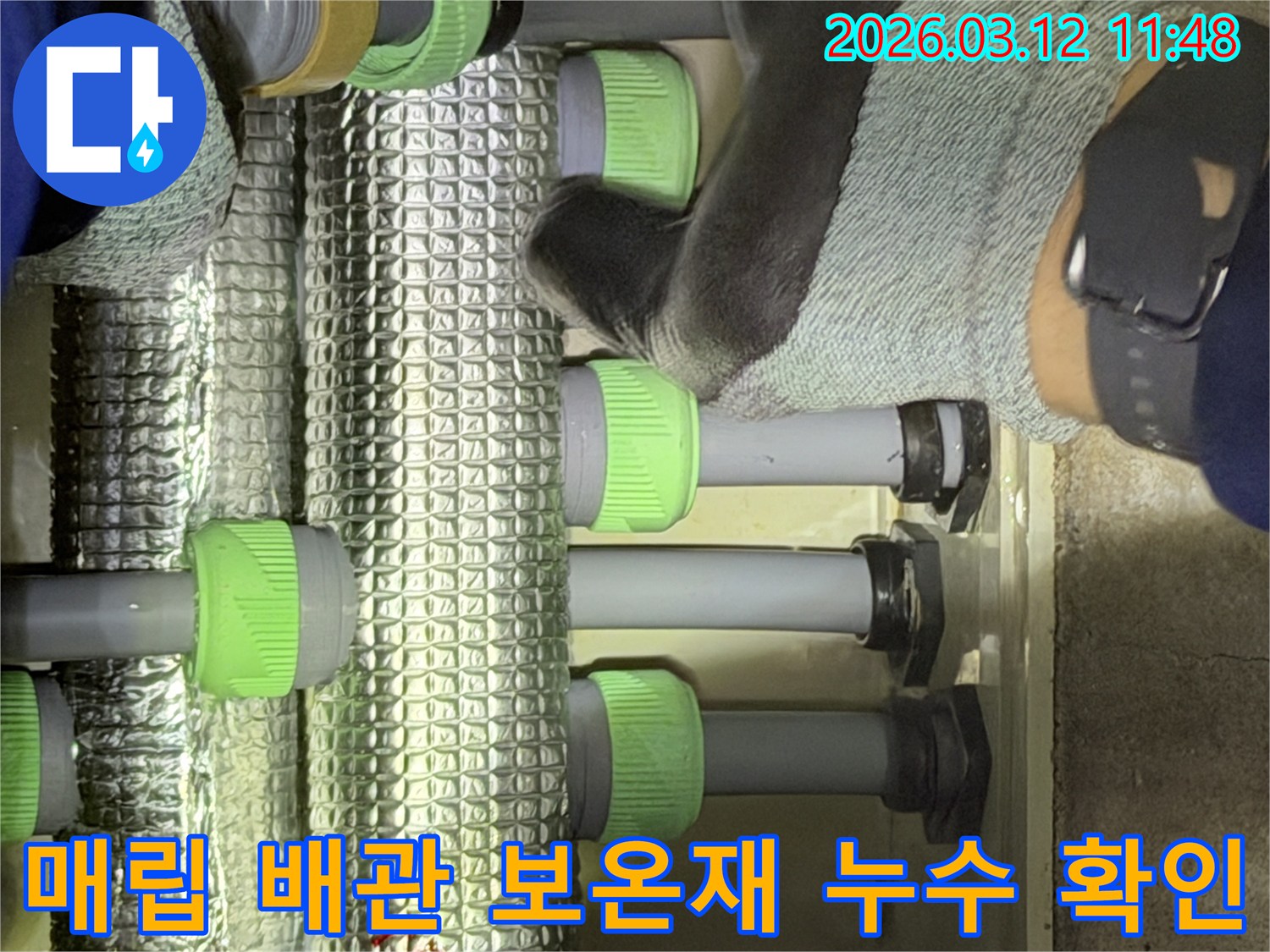 김포-지역의-전문-기술자가-매립된-수도관의-은색-보온재-내부를-살펴보며-누수-지점을-확인하고-있습니다.