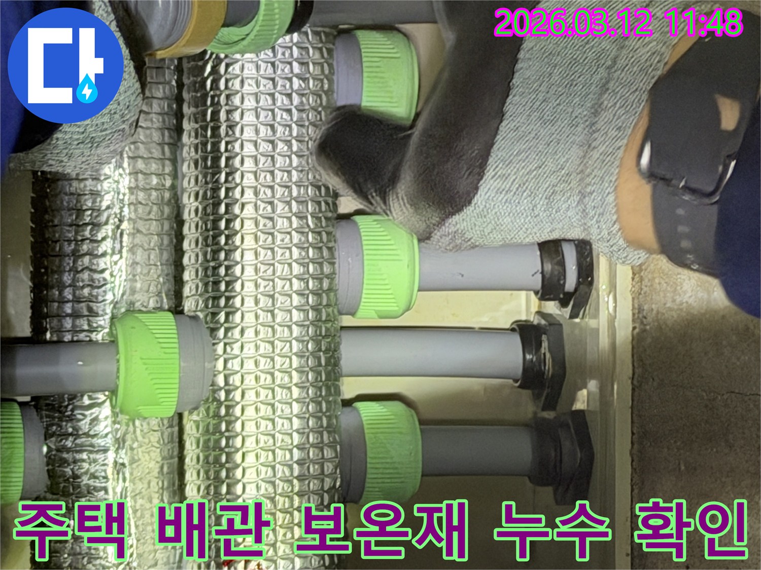 김포-지역의-전문-기술자가-주택-배관의-은색-보온재-내부를-살펴보며-누수-지점을-확인하고-있습니다.