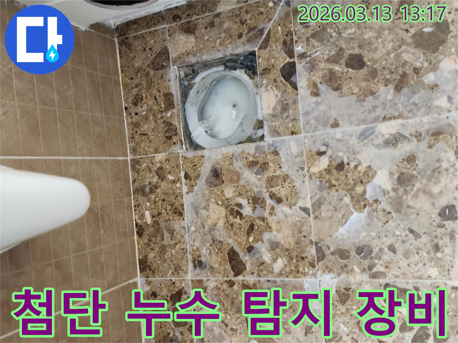 화장실 바닥 배수구 주변에서-첨단 누수 탐지 장비를 활용하여-누수 지점을 파악하는 모습입니다.