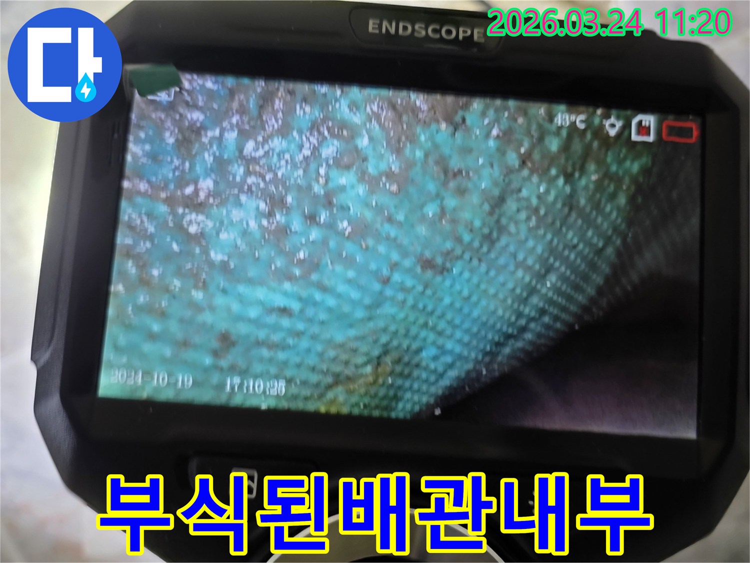 누수 엔지니어가 내시경 장비를 활용하여-부식으로 심하게 오염된 수도관 내부를 면밀히 관찰하는 장면입니다.