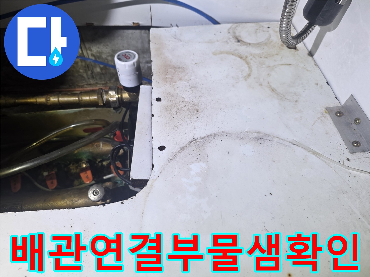 싱크대 하단의 수도 밸브와 금속 연결 부위 상세 사진