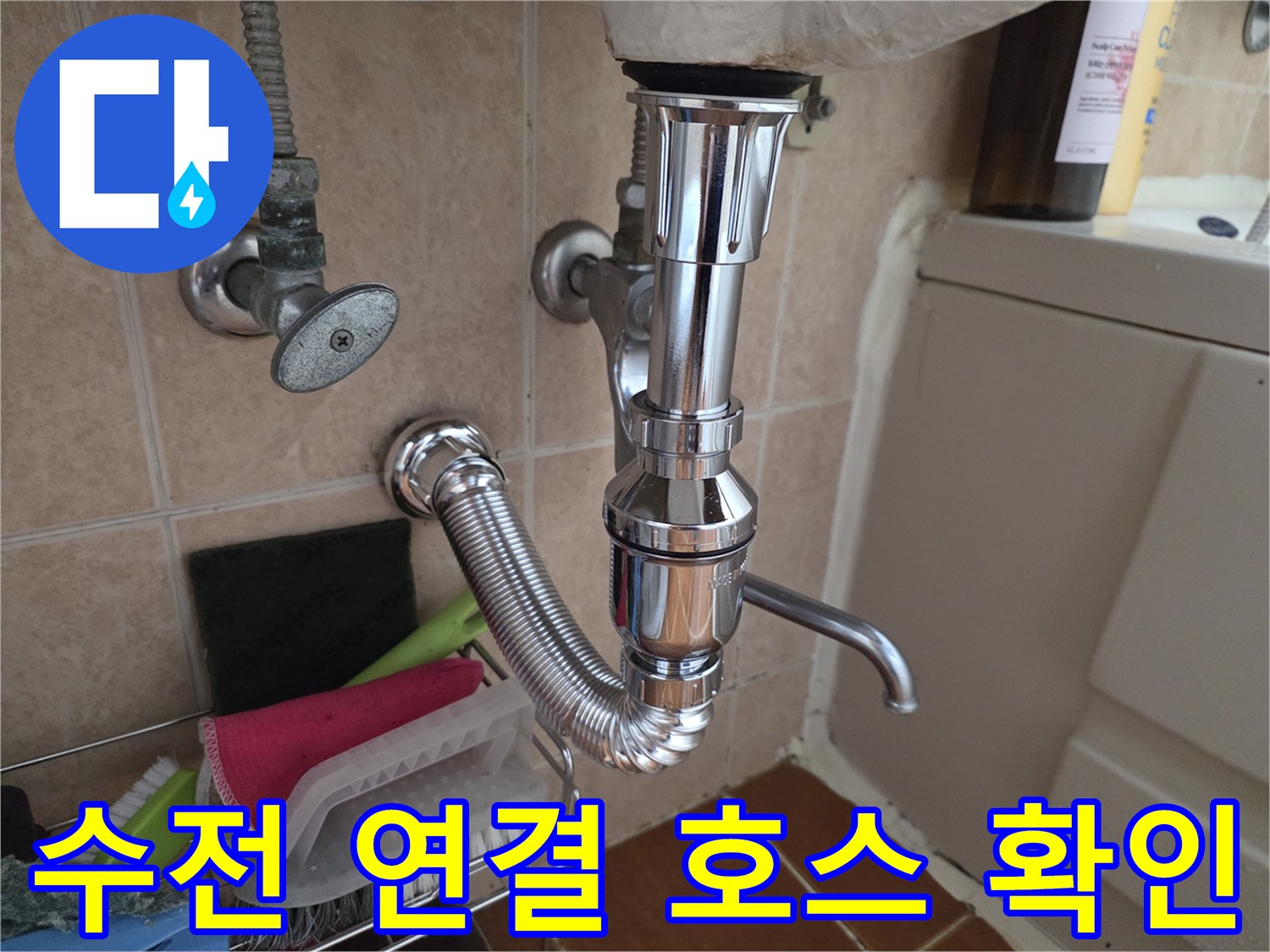 싱크대 하부 수전으로 들어가는 급수 배관과 밸브의 근접 촬영 사진입니다.