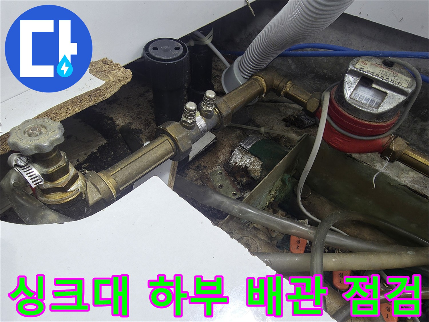 오산 운암동 싱크대 하부의 노후된 급수 배관과 계량기 상태를 점검하는 모습