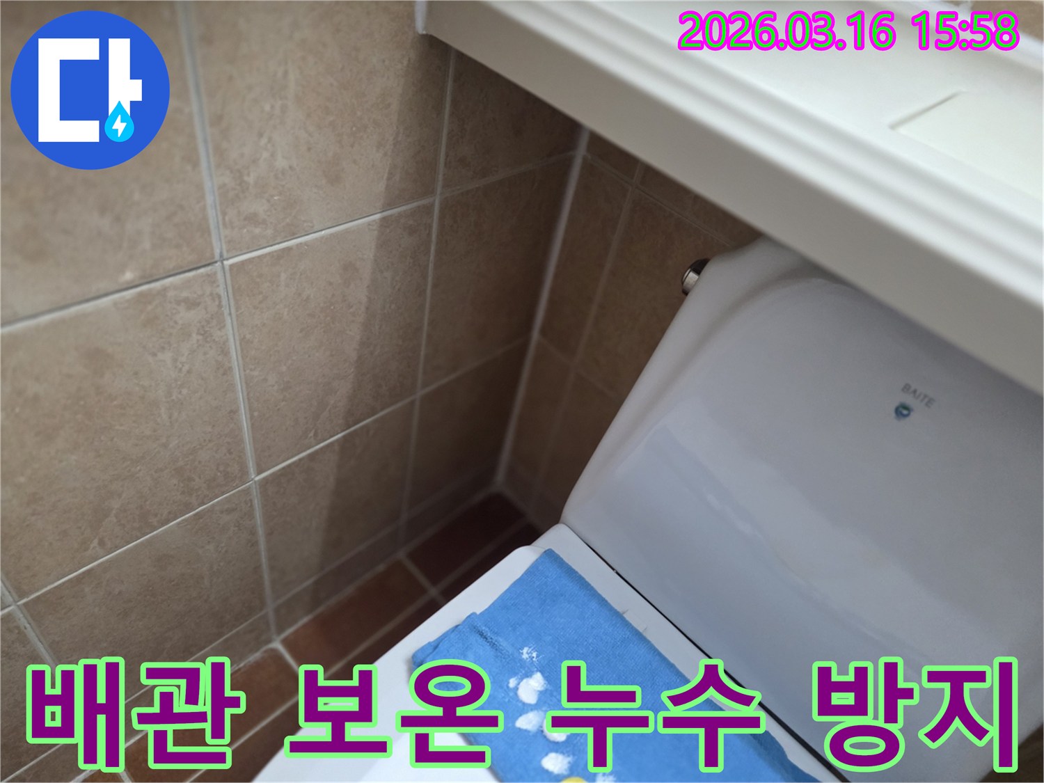 오산 운암로의-한 화장실에서-변기 뒤편-벽면 타일의 젖음으로-누수 수리 후-배관 보온 작업을-진행하는 현장을-보여주는 사진입니다.