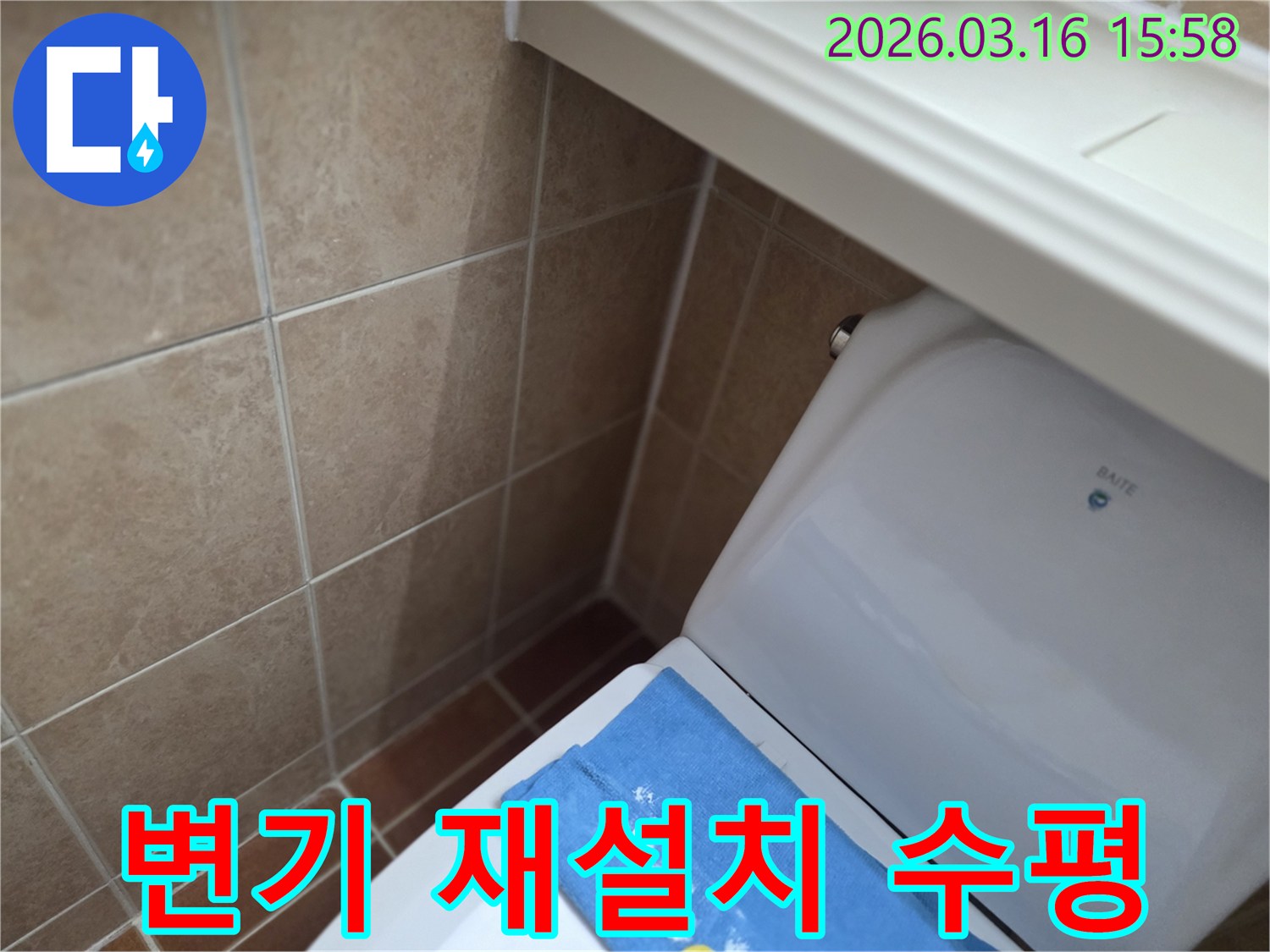 오산시 운암동의-한 욕실에서-변기 뒤편-벽면 타일의 젖음으로-누수 수리 후-변기를 재설치하고-수평을 조절하는-현장을 보여주는-사진입니다.