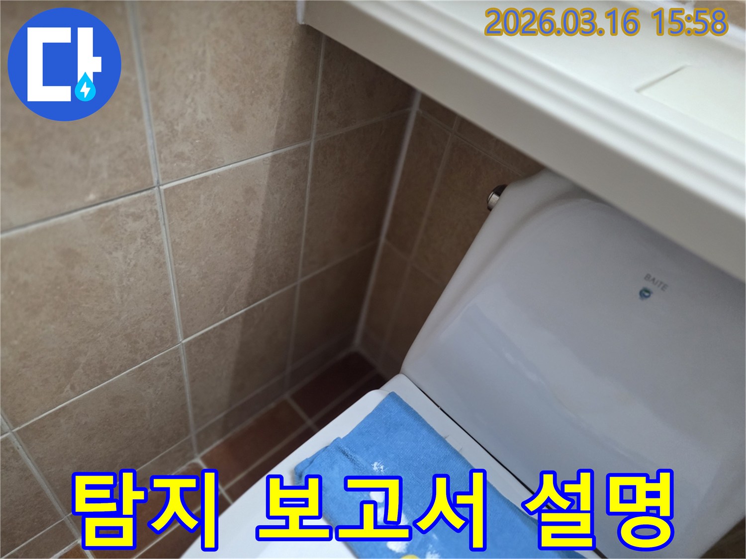 오산시 운암동의-한 욕실에서-변기 뒤편-벽면 타일의 젖음으로-누수 탐지 후-보고서를 작성하고-설명하는 현장을-보여주는 사진입니다.
