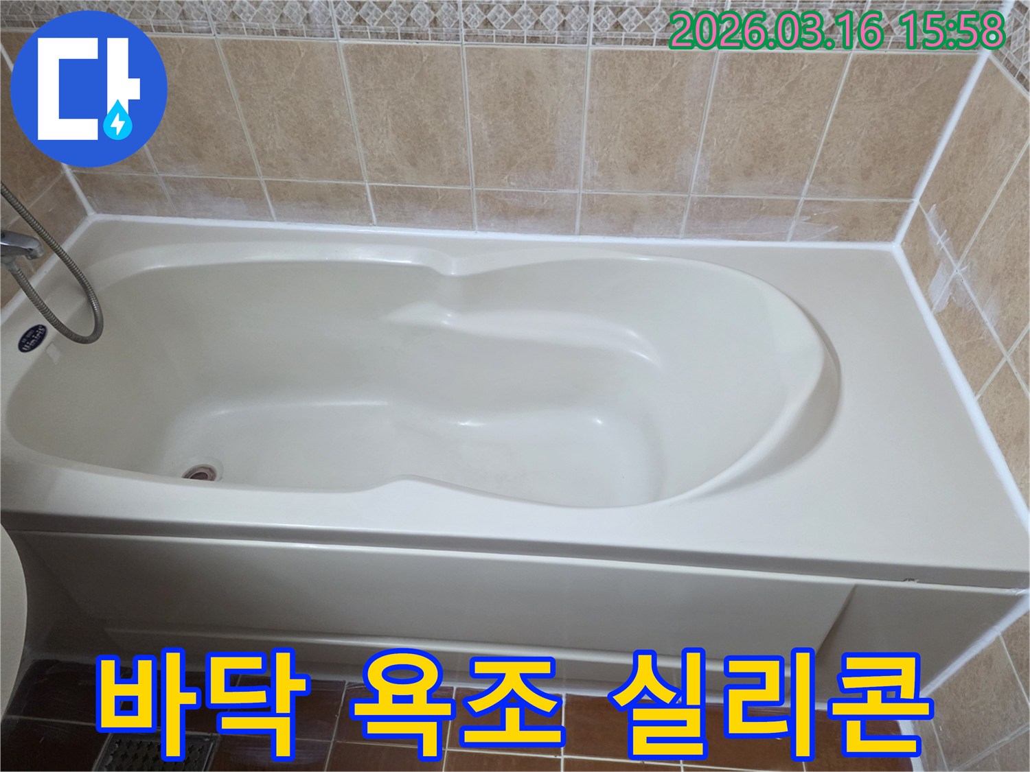 욕실 욕조 하단부와 바닥 타일 사이에-새로운 방수 실리콘이 견고하게 시공되어-물이 스며들 틈을 완벽하게 차단하는 사진입니다