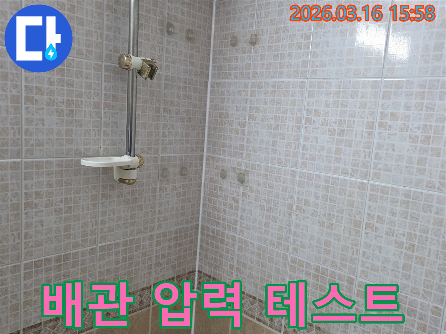 욕실 천장 타일에 물이 새어 생긴-얼룩 주변에서 배관 압력 테스트를-진행하여 누수 원인을 규명하는 모습