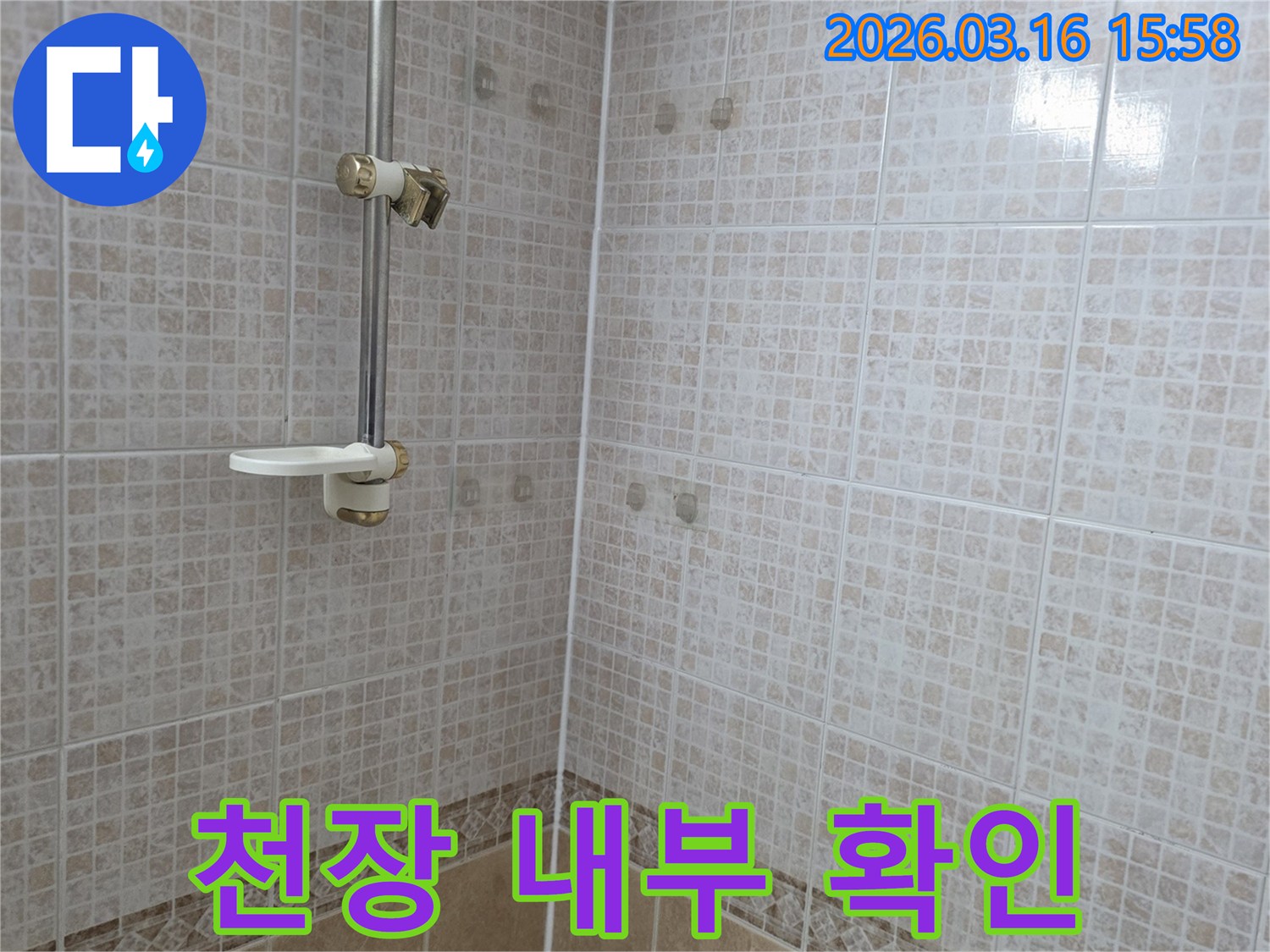 욕실 천장 타일에 물이 새어 생긴-얼룩으로 천장 위 숨겨진 공간의-누수를 누수 전문가가 확인하고 점검하는 모습