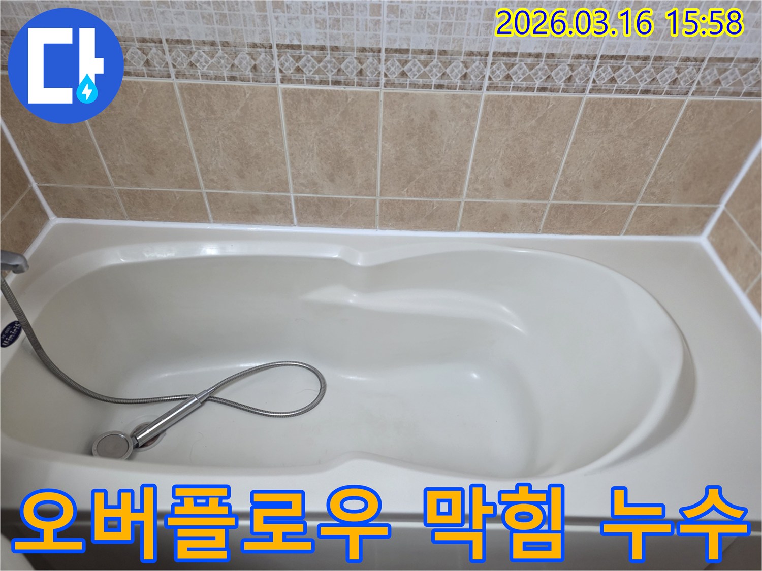 욕실의-흰색-욕조와-샤워기-그리고-타일이-보이는-욕조-오버플로우-배수구-막힘으로-인한-누수를-점검하는-현장-사진입니다