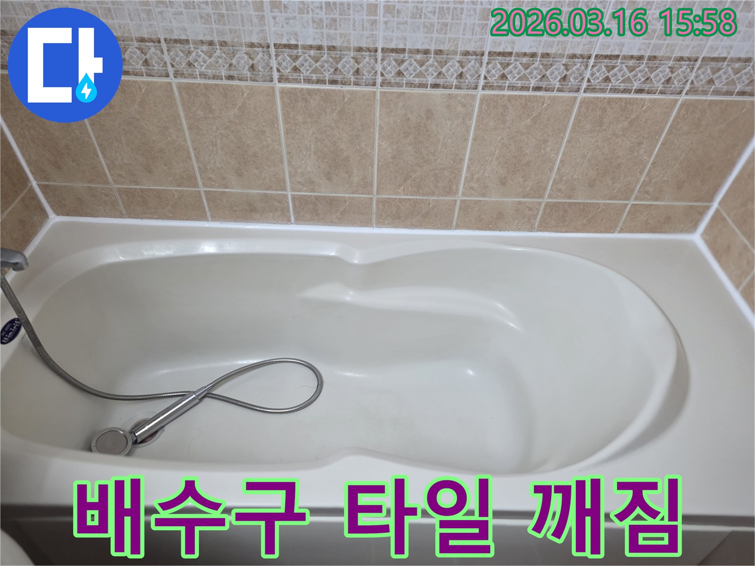 욕실의-흰색-욕조와-타일-그리고-샤워기가-보이는-욕조-배수구-주변-타일-깨짐으로-인한-누수를-점검하는-현장-사진입니다