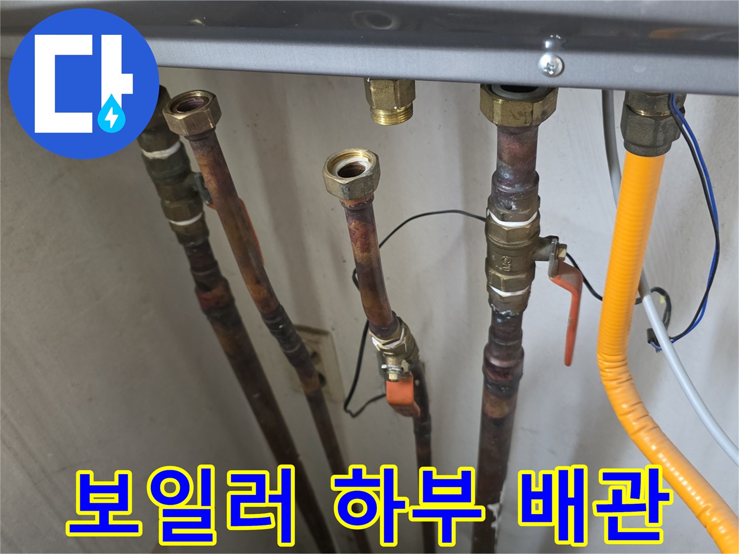 금속 재질의 배관과 노란색 유연한 호스가 연결된 모습입니다.