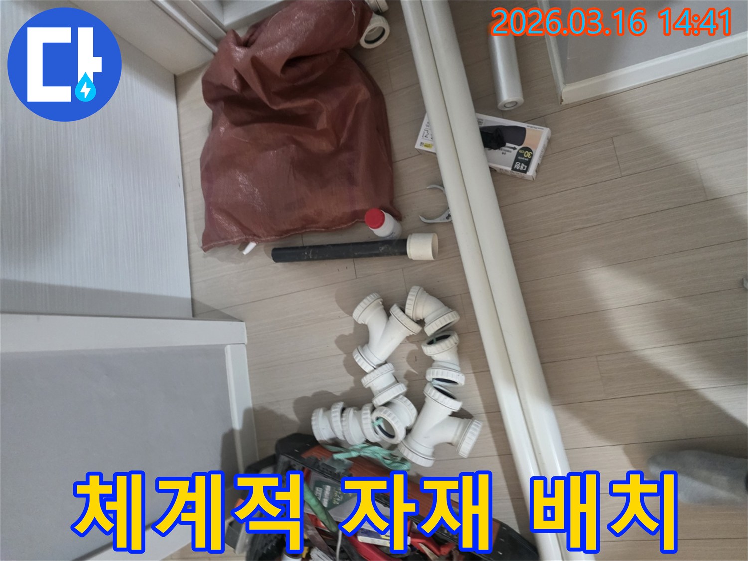 누수-공사에-필요한-다양한-종류의-배관-파이프와-연결-부품-그리고-공구들이-작업-효율을-고려하여-체계적으로-배치되어-있습니다