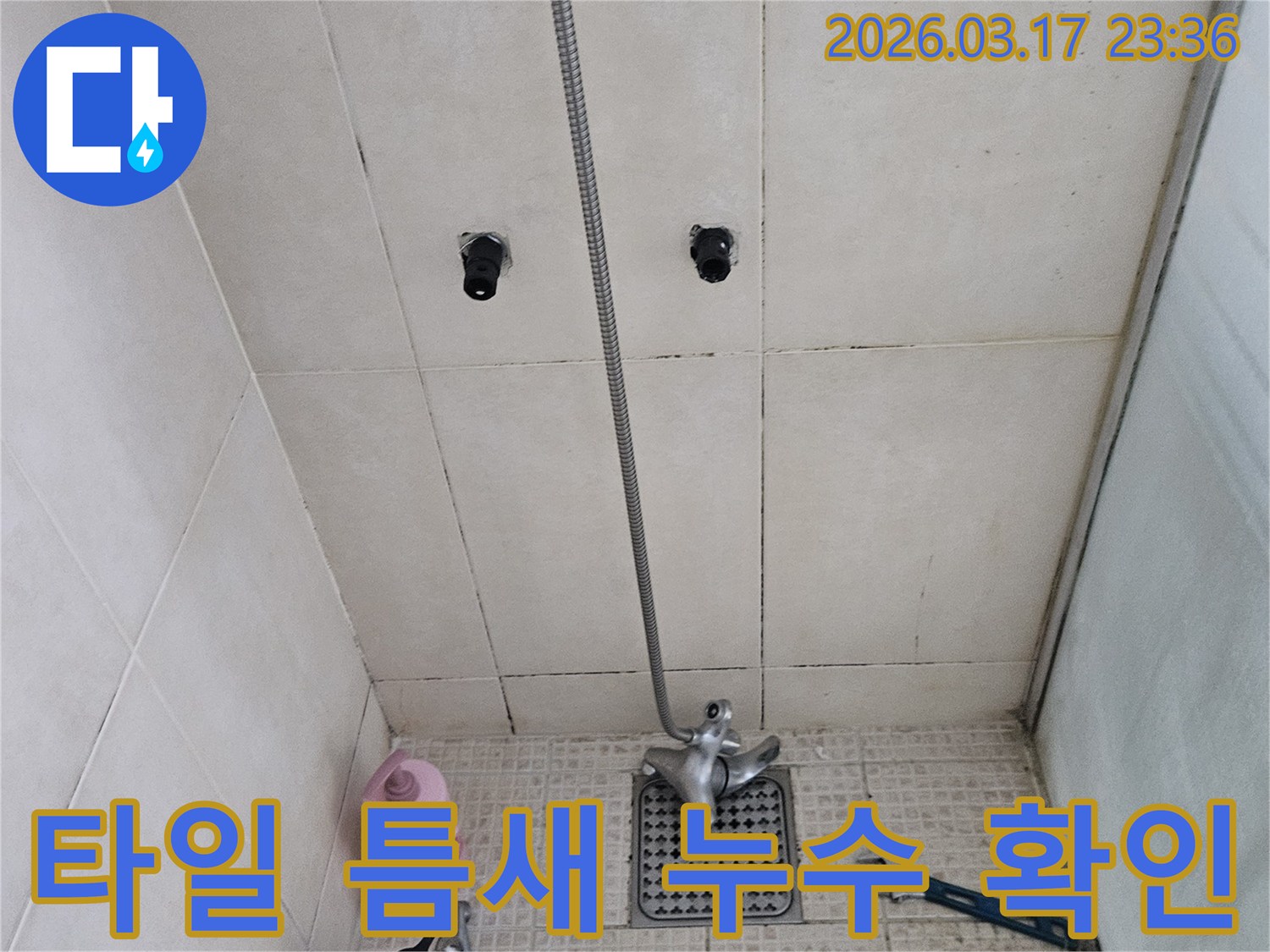 고객님 댁의-화장실 타일-틈새에서-발생한-누수를-해결하기 위해-저희 팀이-배관 상태를-면밀히-살펴보고 있는-현장 사진입니다.