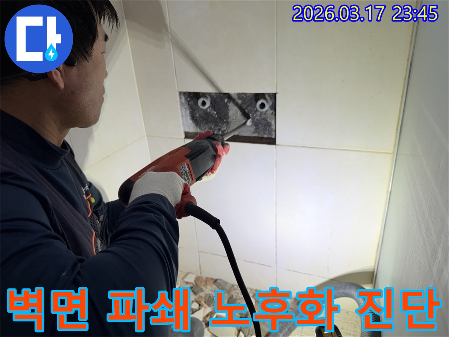 누수 공사 전문가가 주택 욕실 벽면의 타일을 조심스럽게 파쇄하여-누수 원인 배관의 노후화 여부를 진단하는 모습입니다.