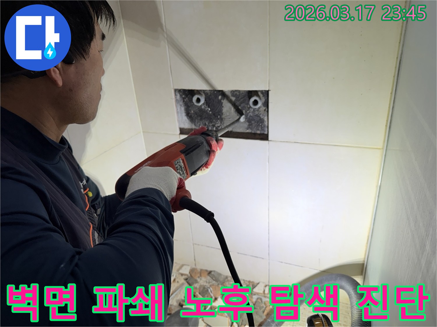 누수 전문가가 벽면 타일을 깨끗하게 파쇄하며-누수 원인인 배관의 노후화 여부를 정밀하게 탐색하고 진단하는 작업을 진행 중입니다.