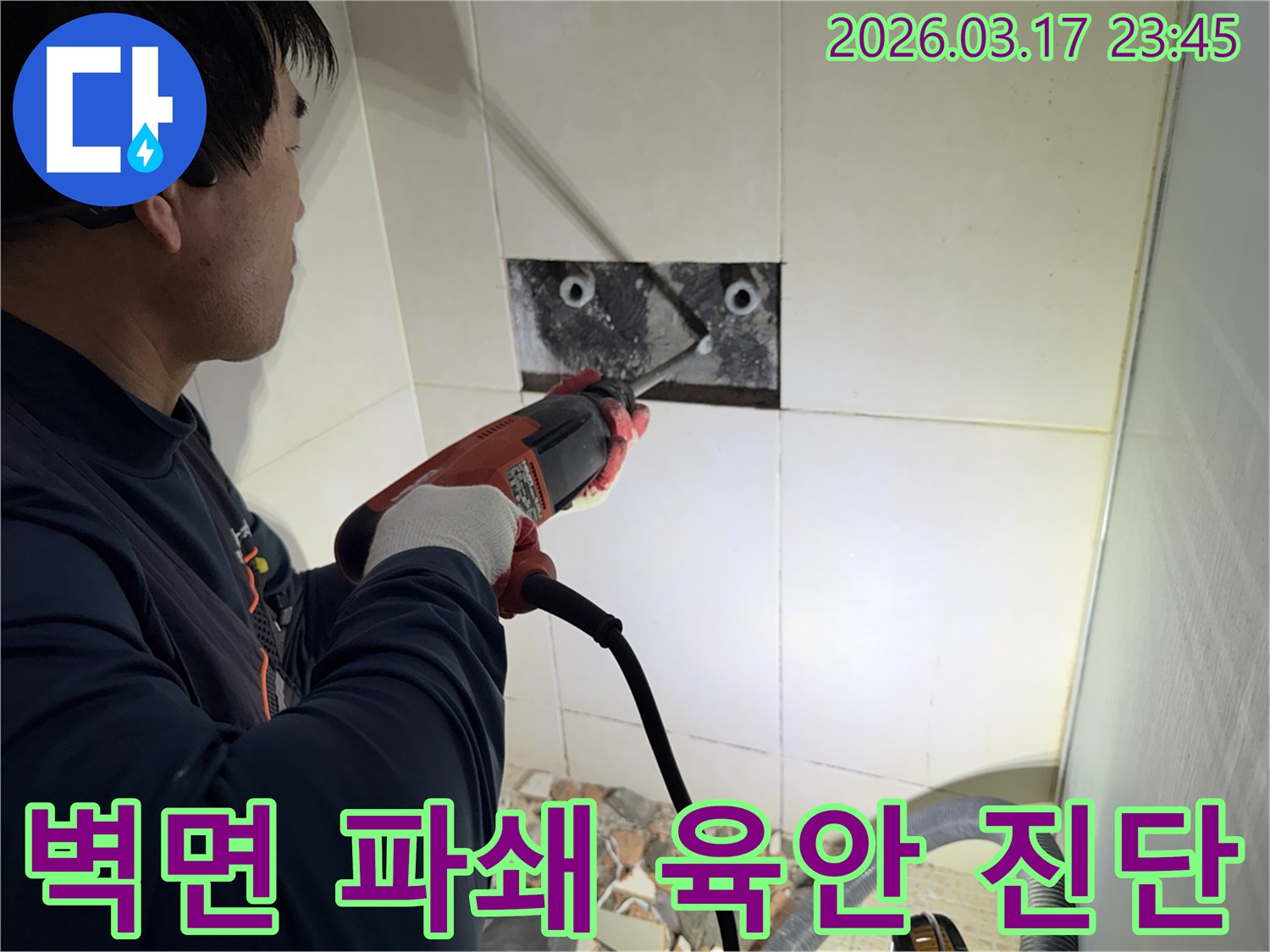 누수 전문가가 벽면 타일을 깨끗하게 파쇄하며-누수 원인인 배관의 문제점을 육안으로 검사하고 진단하는 작업을 진행 중입니다.