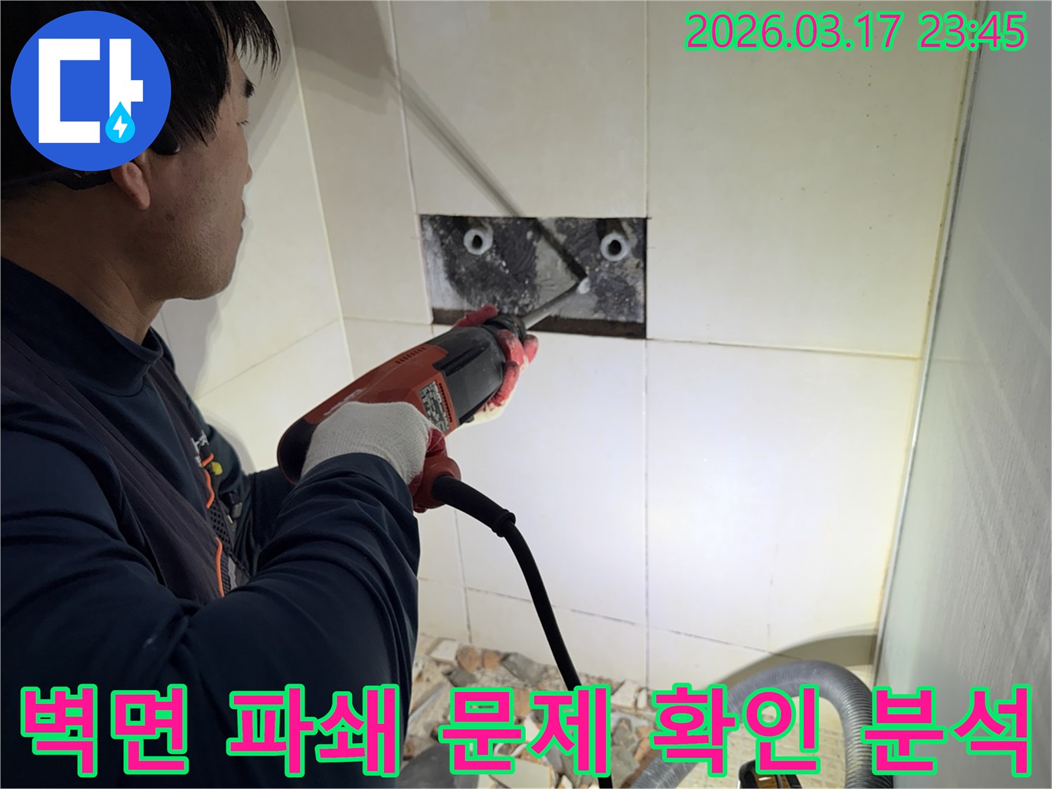 누수 전문가가 벽면 타일을 깨끗하게 파쇄하며-누수 원인인 배관의 문제점을 육안으로 확인하고 분석하는 작업을 진행 중입니다.