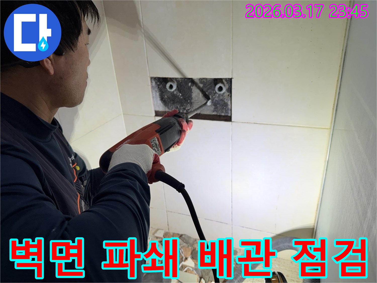 누수 전문가가 벽면 타일을 깨끗하게 파쇄하며-누수 원인인 배관의 문제점을 정밀하게 점검하는 작업을 진행 중입니다.