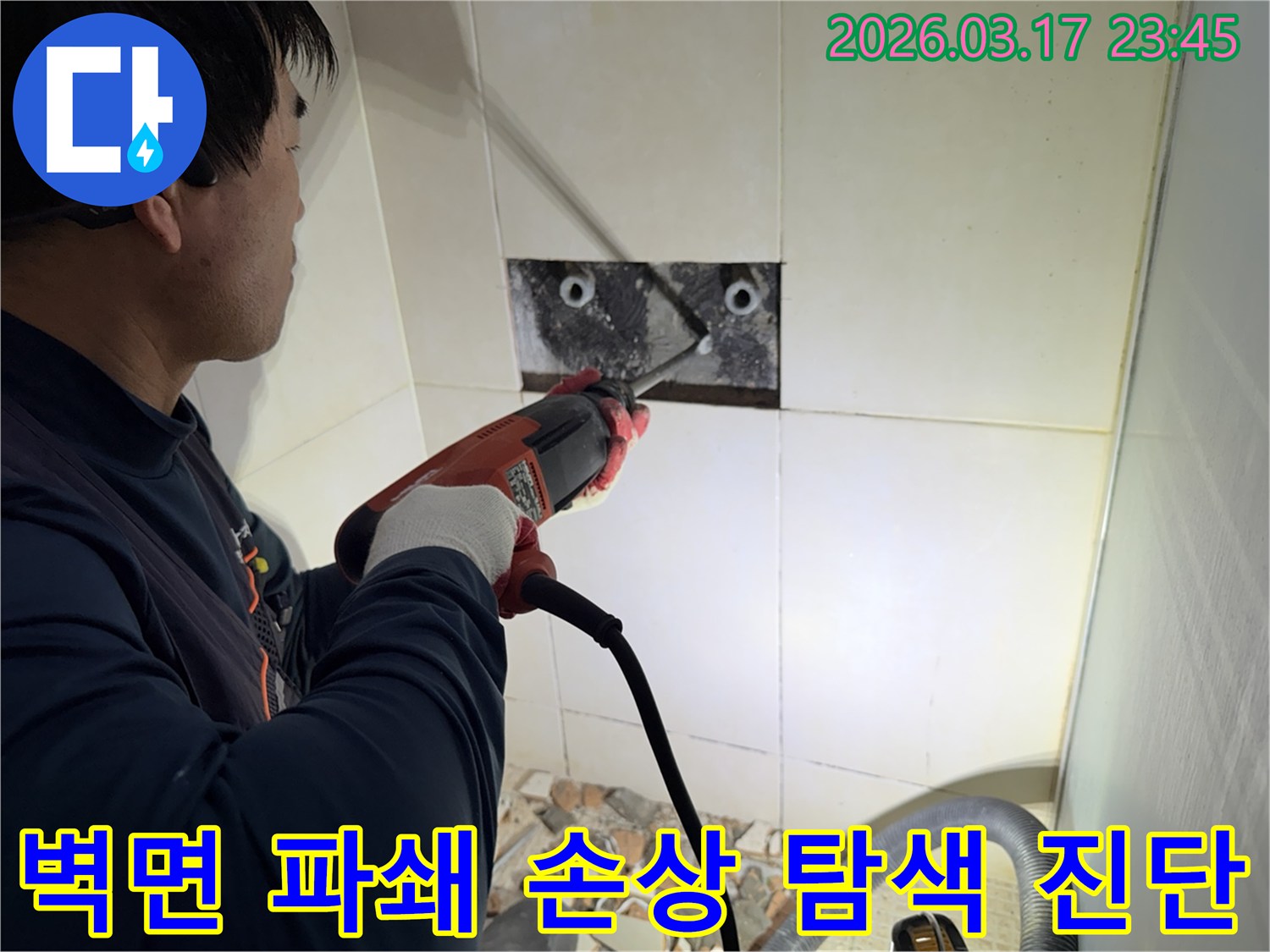 누수 전문가가 벽면 타일을 깨끗하게 파쇄하며-누수 원인인 배관의 손상 부위를 정밀하게 탐색하고 진단하는 작업을 진행 중입니다.