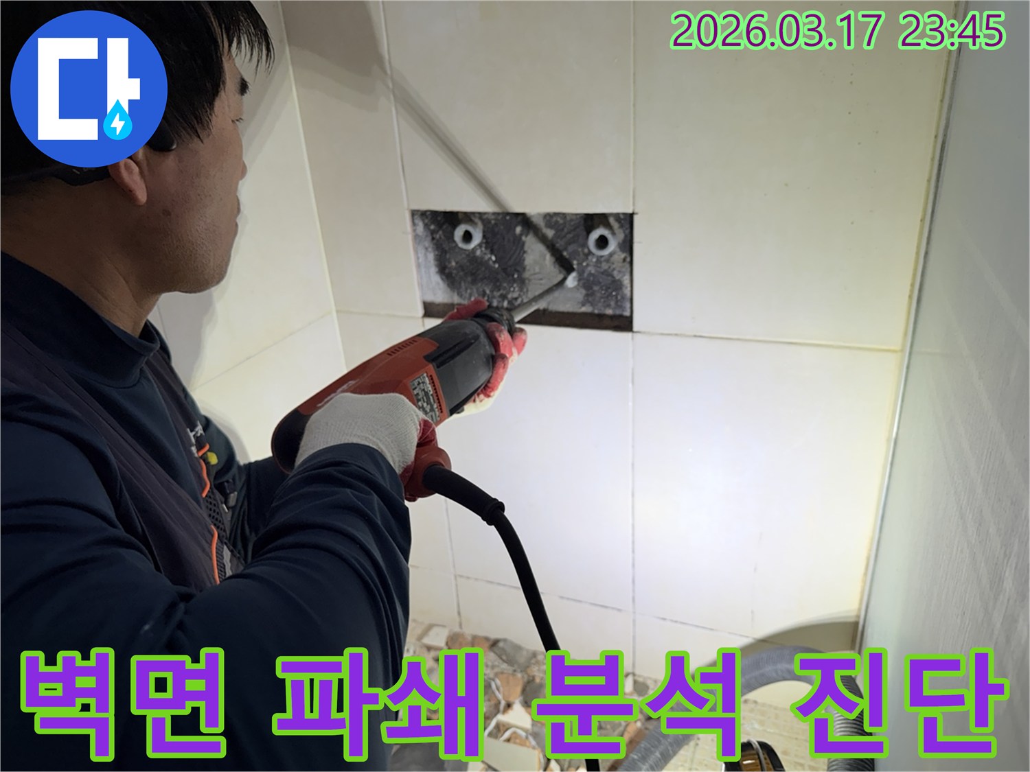 누수 전문가가 사무실 벽면 타일을 깨끗하게 파쇄하며-누수 원인인 배관의 문제점을 정밀하게 분석하고 진단하는 작업을 진행 중입니다.