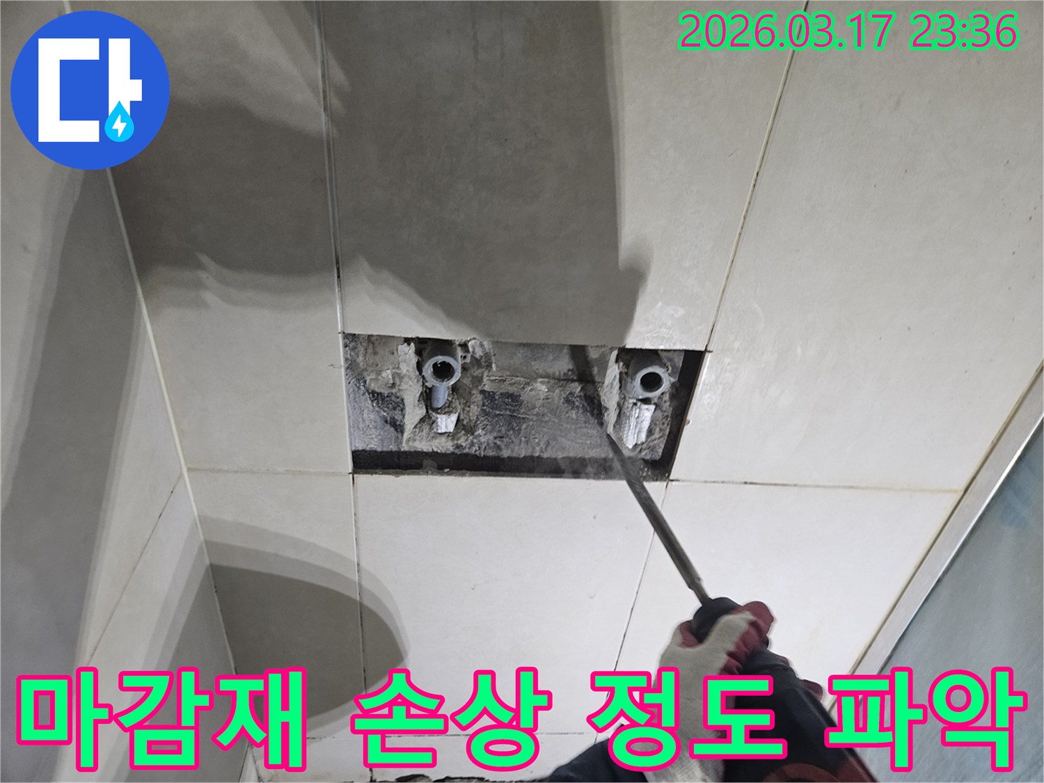 누수 지점을-정확히 찾기 위해-타일 벽면을-개방하여-배관 주변 마감재의-손상 정도를-면밀히-파악하는 작업 현장
