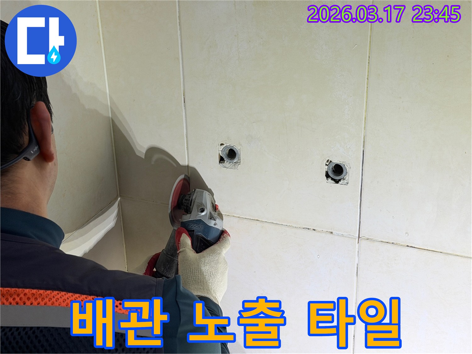 누수된 배관을-노출시키기 위해-전문가가-타일 벽면을-그라인더로-조심스럽게-제거하고-있습니다