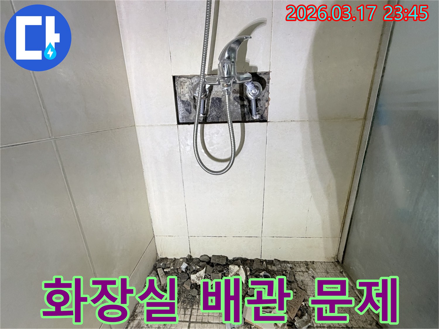 병점 아파트 화장실 누수 현장에서-배관 문제 해결을 위해-샤워 수전이 제거되고-바닥 타일이 파손된 채로-공사가 진행 중인 모습입니다.