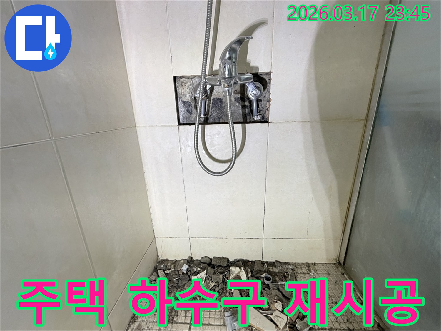 병점 화성 주택 욕실에서-오래된 하수구 배관 누수 교체 및 재시공을 위해-샤워 수전이 제거되고-바닥 타일이 파손된 채로-공사가 진행 중인 모습입니다.