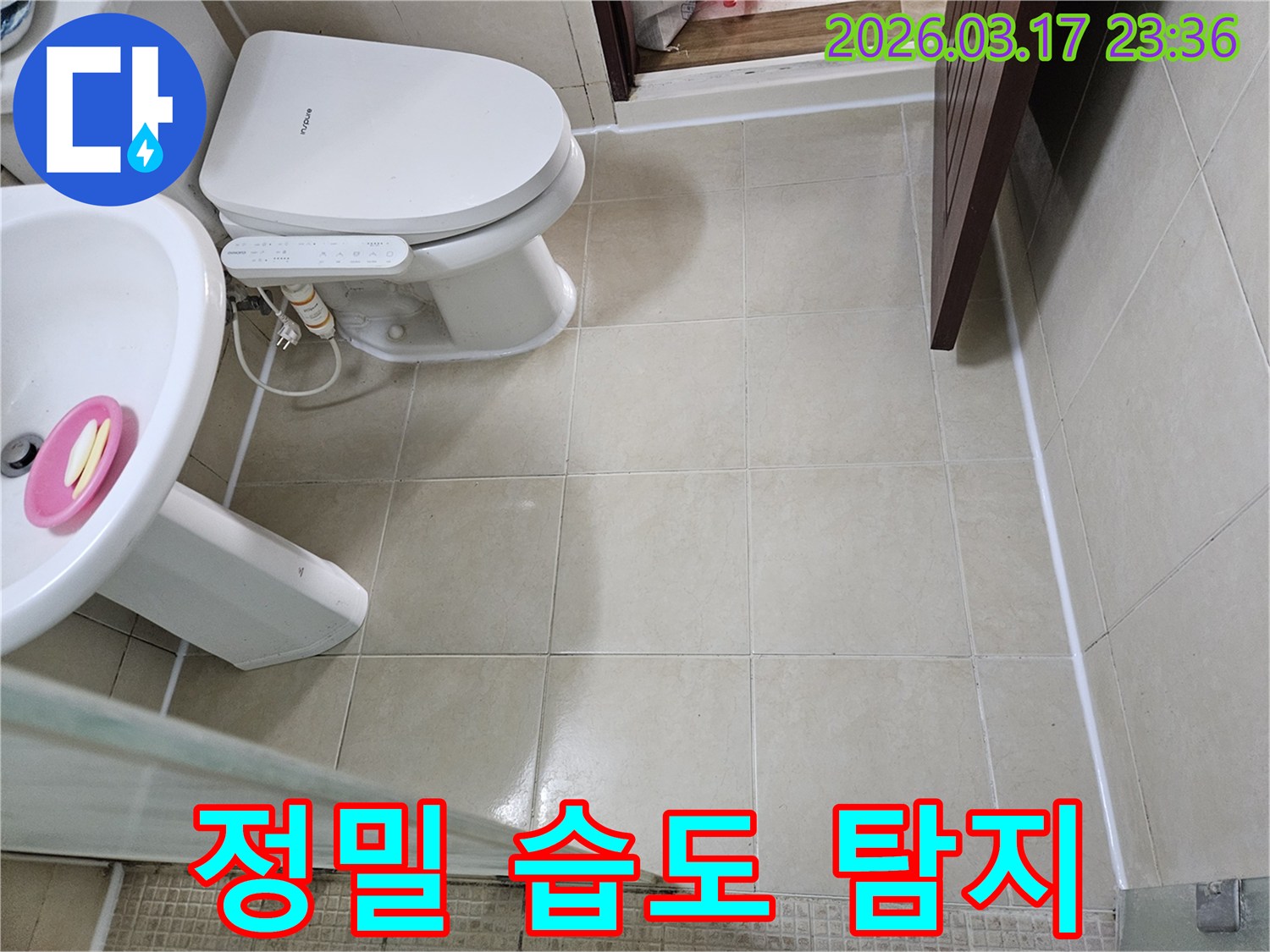 빌라 욕실 바닥 타일과 변기 주변에서-정밀 습도 측정기를 사용하여-육안으로 보이지 않는 숨겨진 습기를-탐지하는 모습입니다