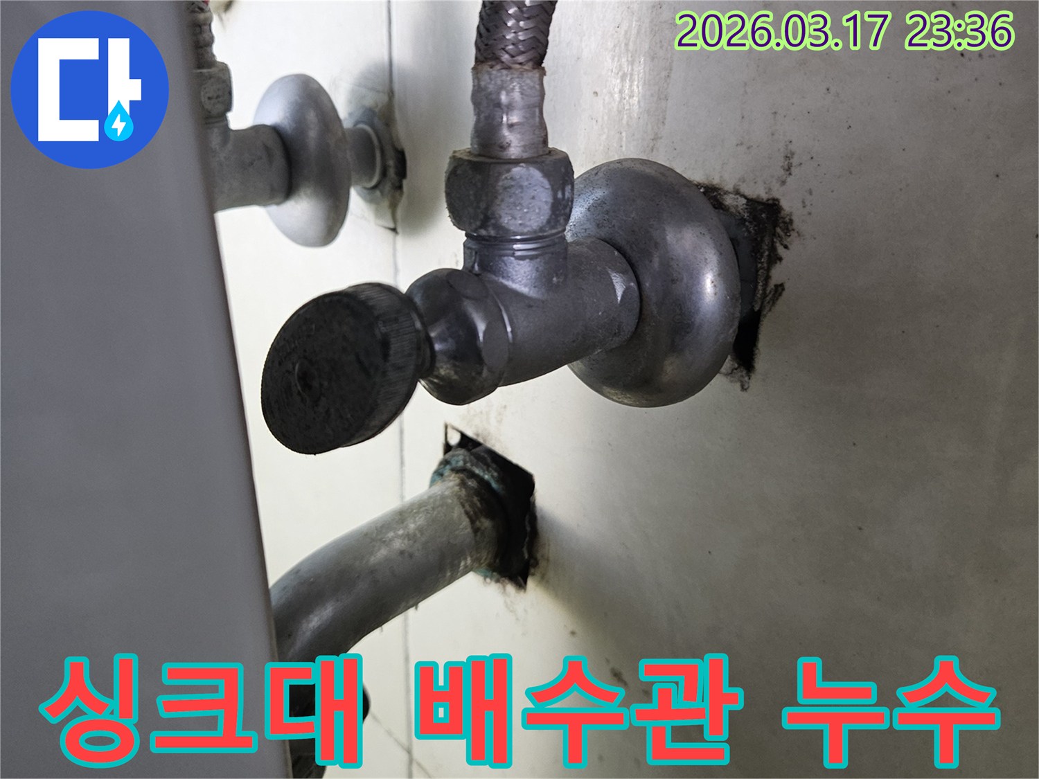 싱크대 하부의 배수관 연결부에서-물이 새어 나와-주변이 젖어 있는-누수 현장 사진입니다.