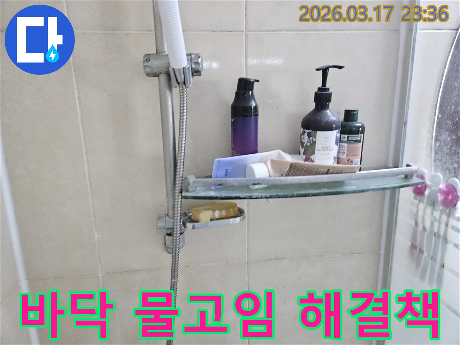 욕실 샤워기 옆-유리 선반에 맺힌 물방울은-바닥 물고임의 간접적인 증거를 보여주는 이미지입니다