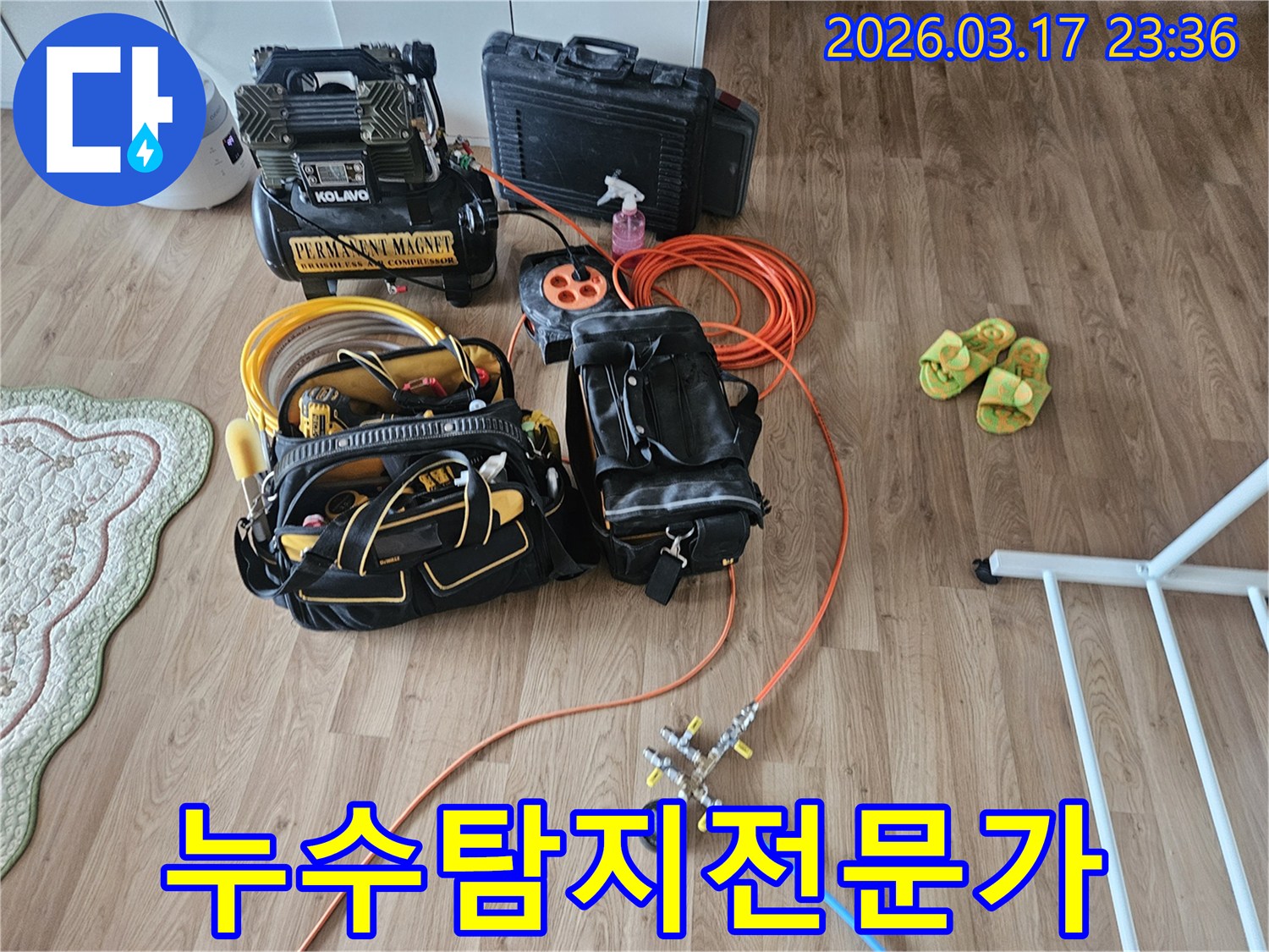 주거 공간 바닥에 놓인 누수 탐지 장비들-정밀한 압력 테스트를 위한 도구와 공구함이 보입니다.
