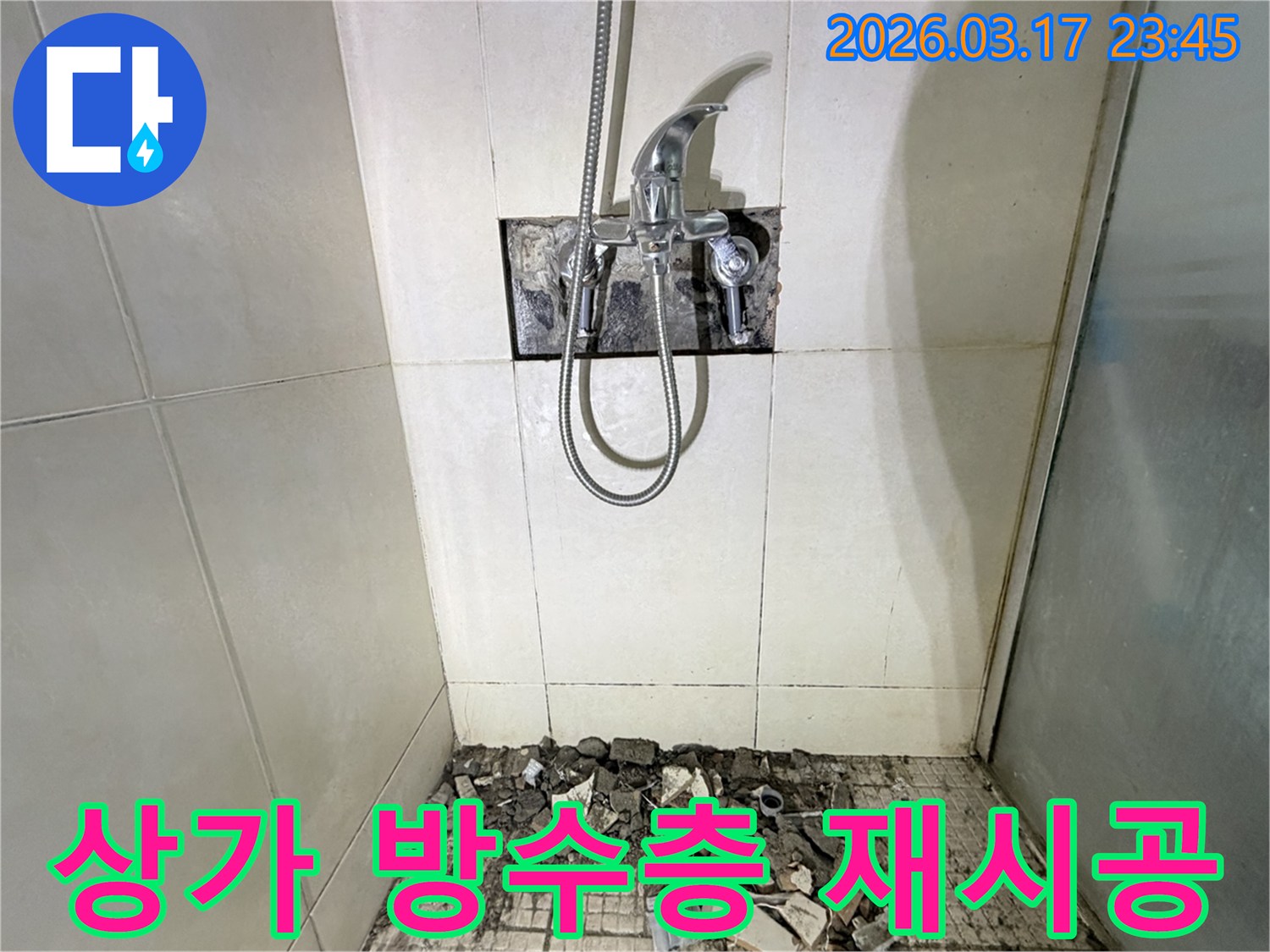 화성 병점 상가 화장실에서-바닥 방수층 손상으로 인한 누수 긴급 보수 및 재시공을 위해-샤워 수전이 제거되고-바닥 타일이 파손된 채로-공사가 진행 중인 모습입니다.
